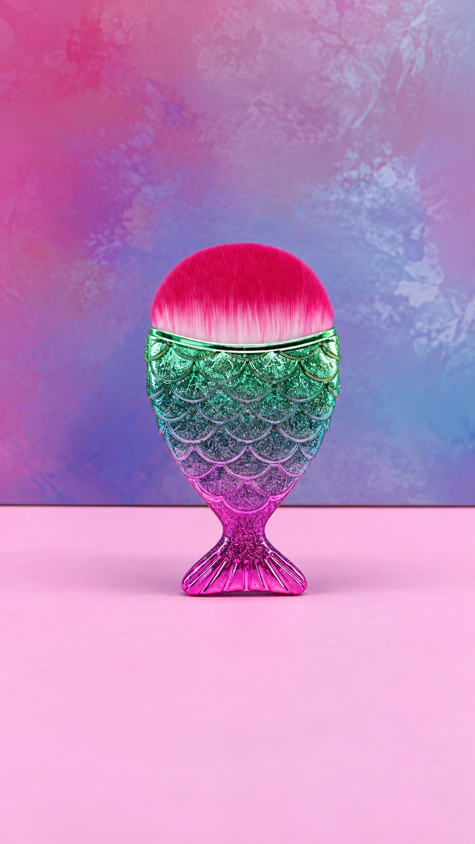 Brocha sirenita para uñas con mango en forma de cola de pez con acabado brillante multicolor y cerdas rosas y blancas.