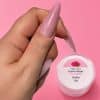 Uñas largas en tono bonbon de PROXGEL Sensitive Builder sobre fondo rosa.